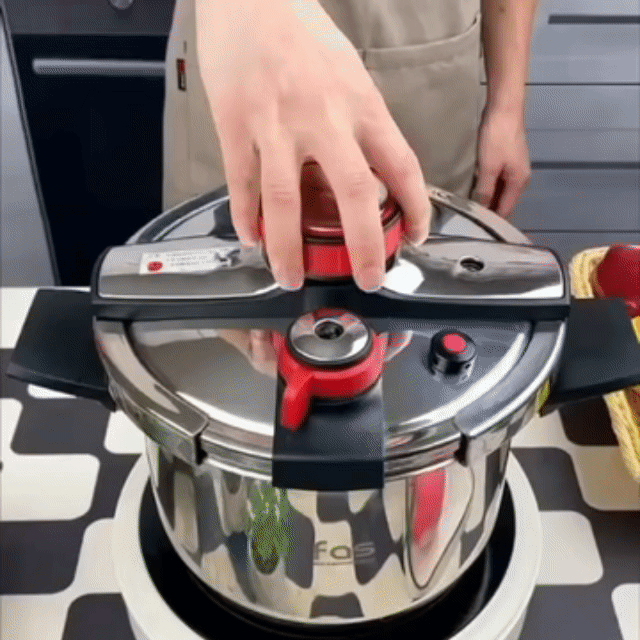 Mão fechando a tampa da panela de pressão UltraChef em aço inox sobre o fogão